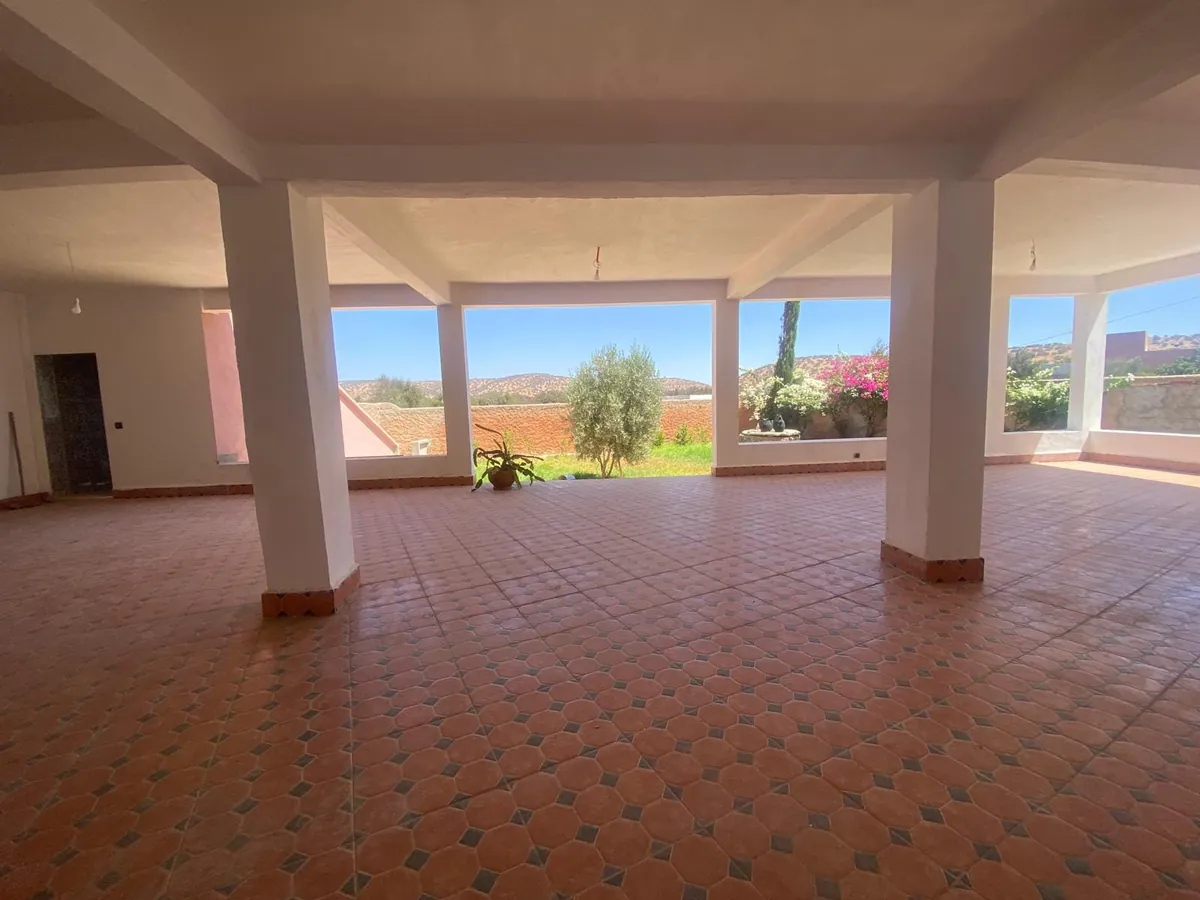 La salle de danse vide, ses piliers blancs et ses baies ouvertes sur la campagne.